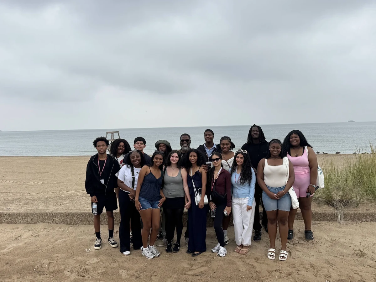 A Landmark student group photographed together on a beach on an overcast day