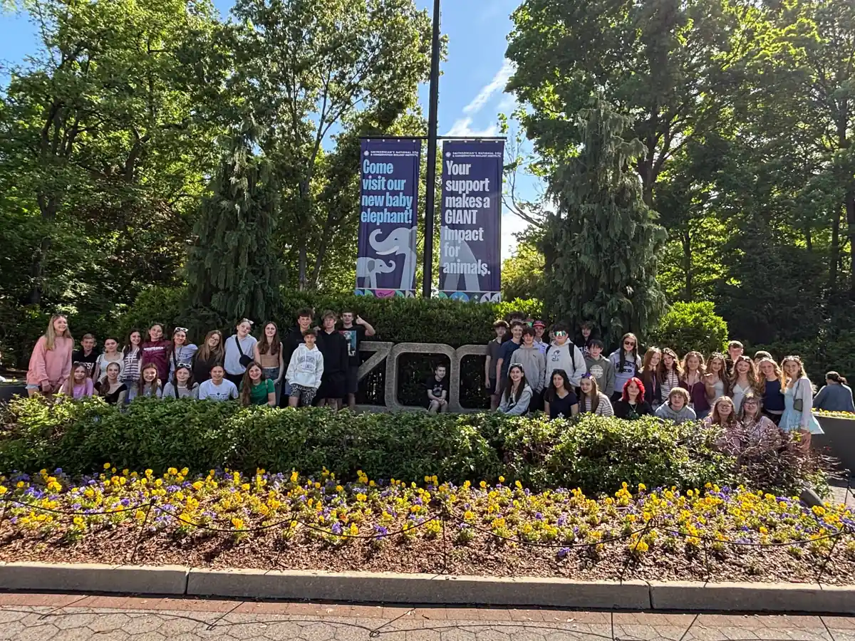 A Landmark student group at the entrance sign to the Smithsonian National Zoo in Washington, DC