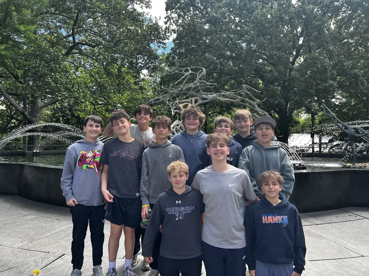 A group of Landmark students standing together beside a park fountain
