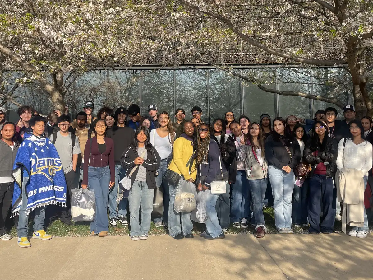 A large Landmark high school group photographed under cherry blossoms outside the National Museum of African American History and Culture in Washington, DC
