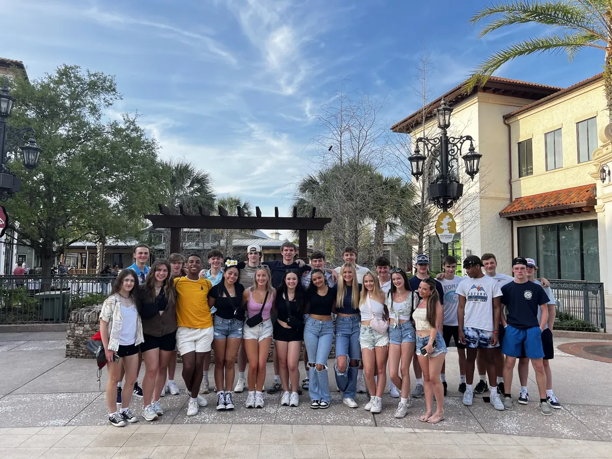 A Landmark student group standing together on a palm-lined walkway at Disney Springs in Orlando
