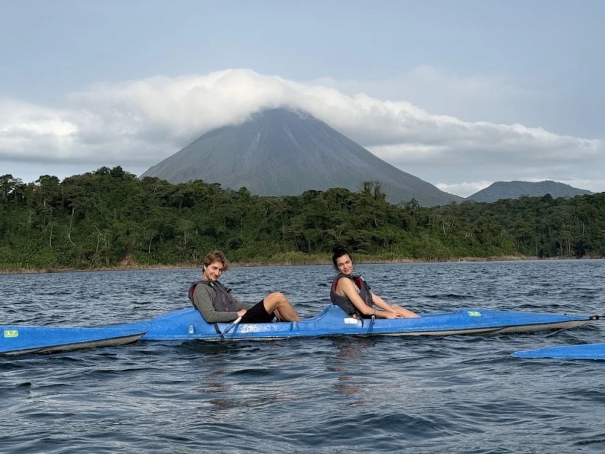 Two Landmark students in a kayak on Arenal Lake with the Arenal Volcano behind them