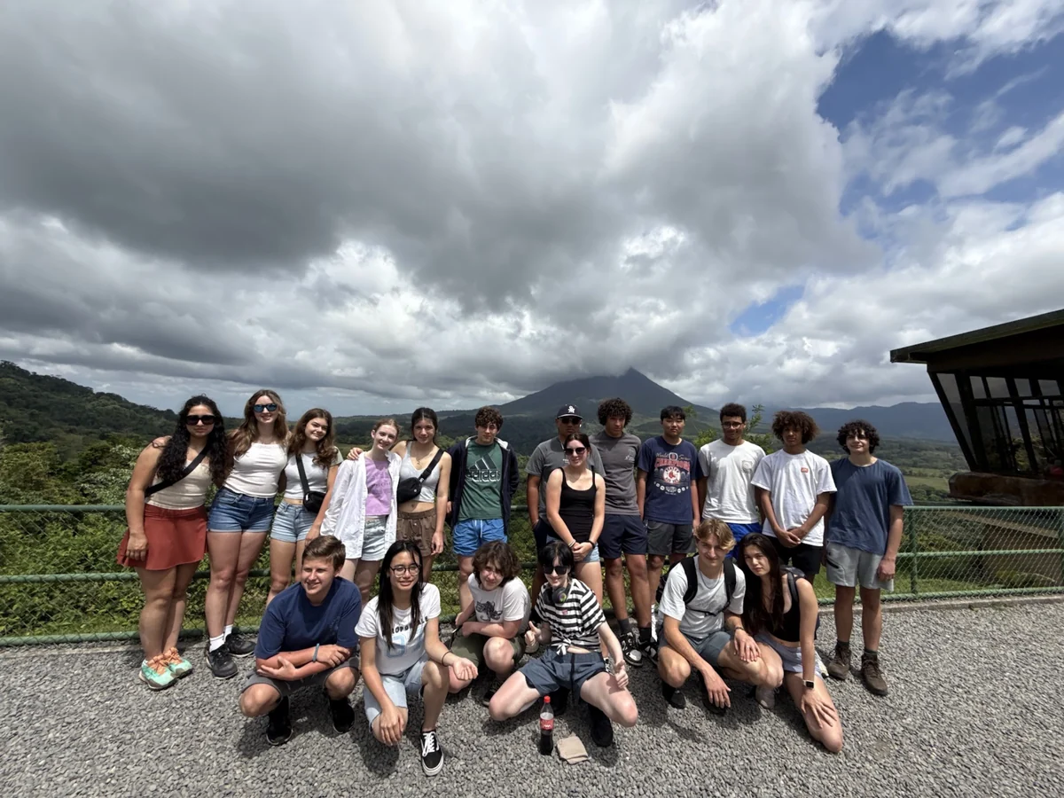 A Landmark student group at a viewpoint with the Arenal Volcano rising behind them