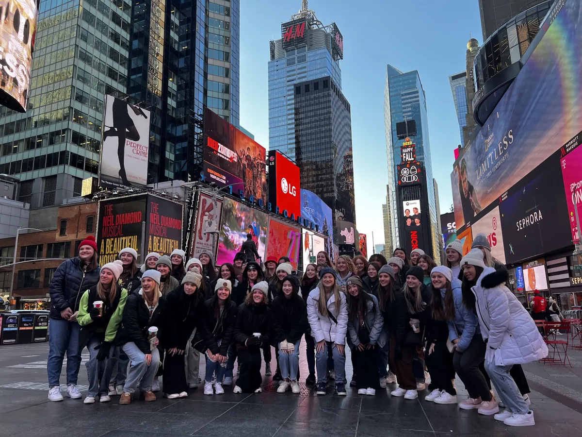 A Landmark student group in winter hats gathered in Times Square, New York City