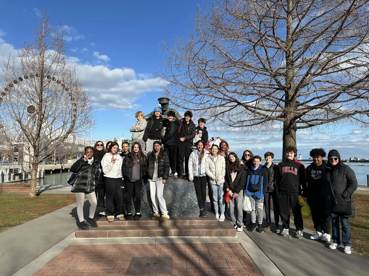 A Landmark student group in winter coats beside a statue near Navy Pier in Chicago
