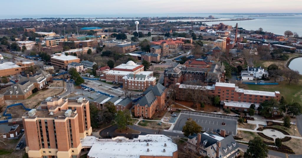An aerial view of Hampton University. The campus sits next to a large body of water in the background.