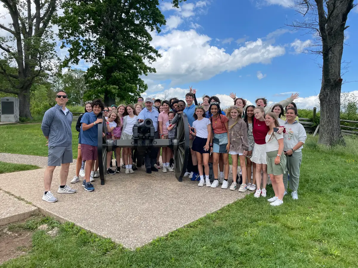 A Landmark student group gathered around a cannon on a Civil War battlefield during a school trip