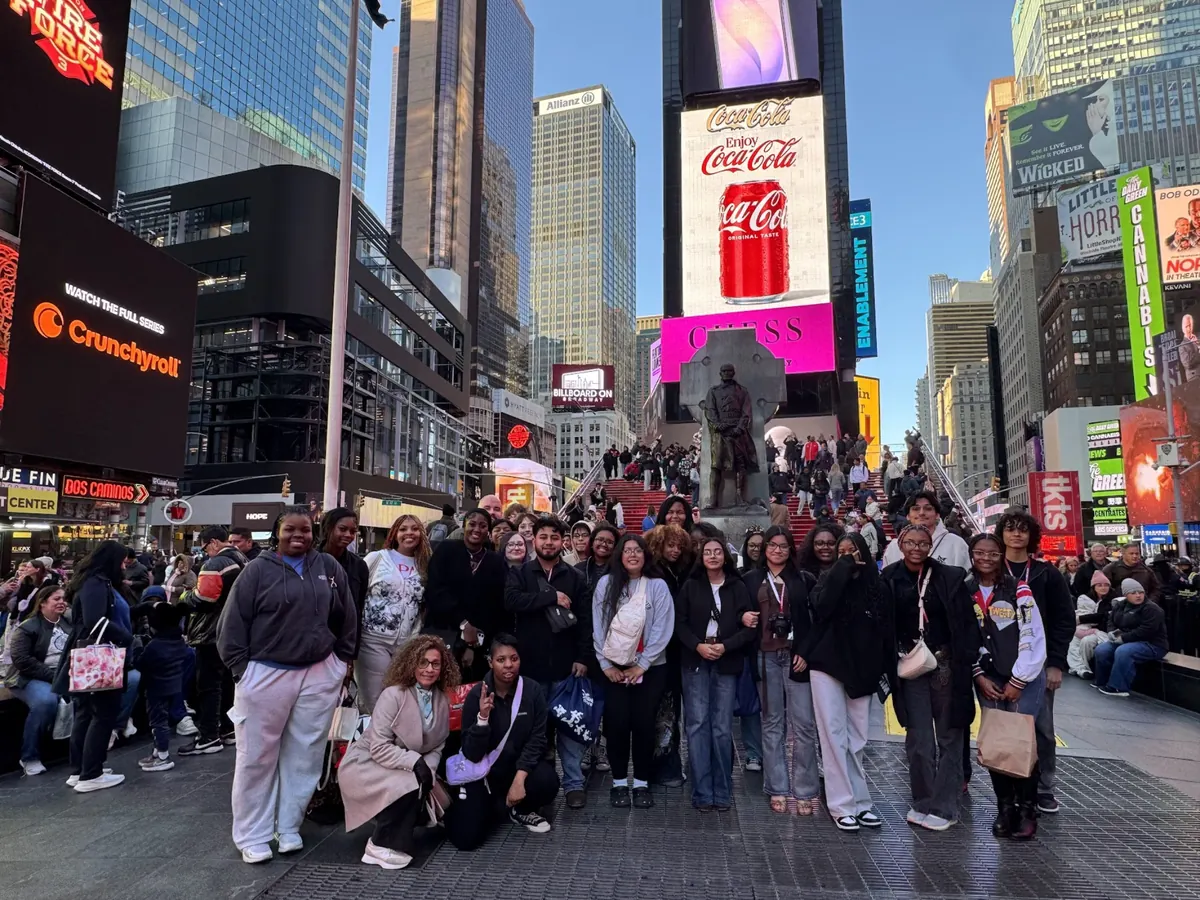 A large Landmark school group photographed in Times Square in New York City with billboards and theatre marquees behind them