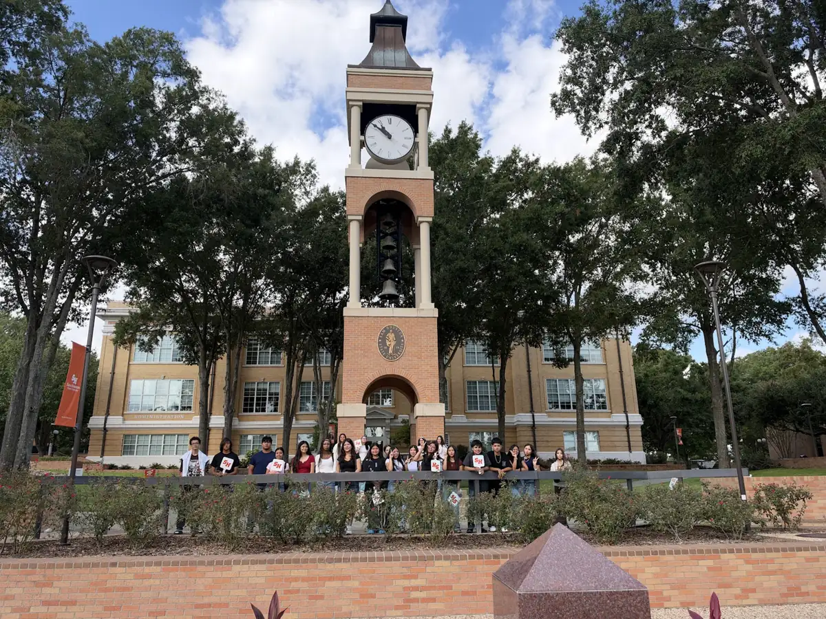 A Landmark student group on a university campus tour beside a clock tower