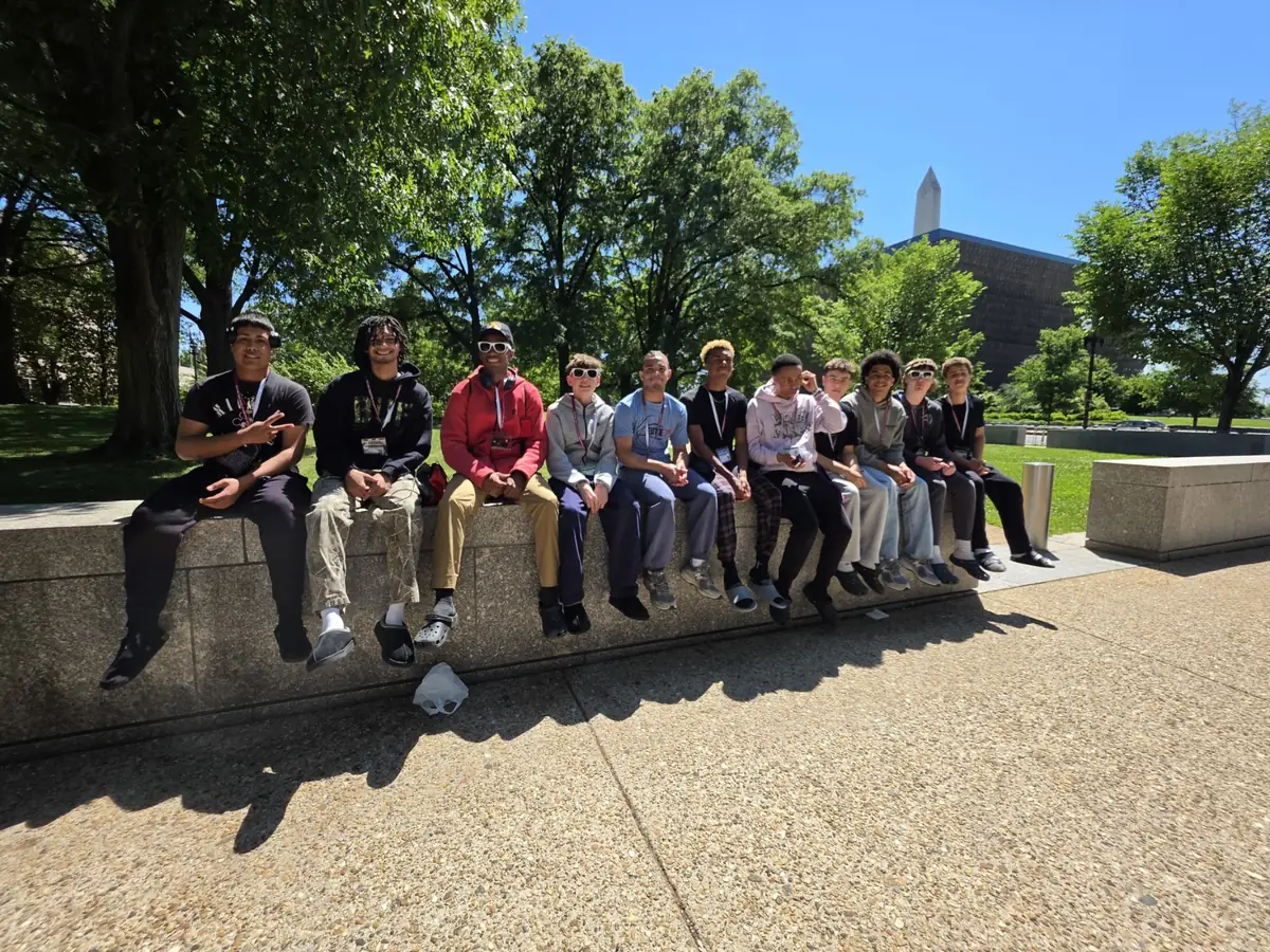 A Landmark high school group sitting together in Washington, D.C. with the Washington Monument behind them