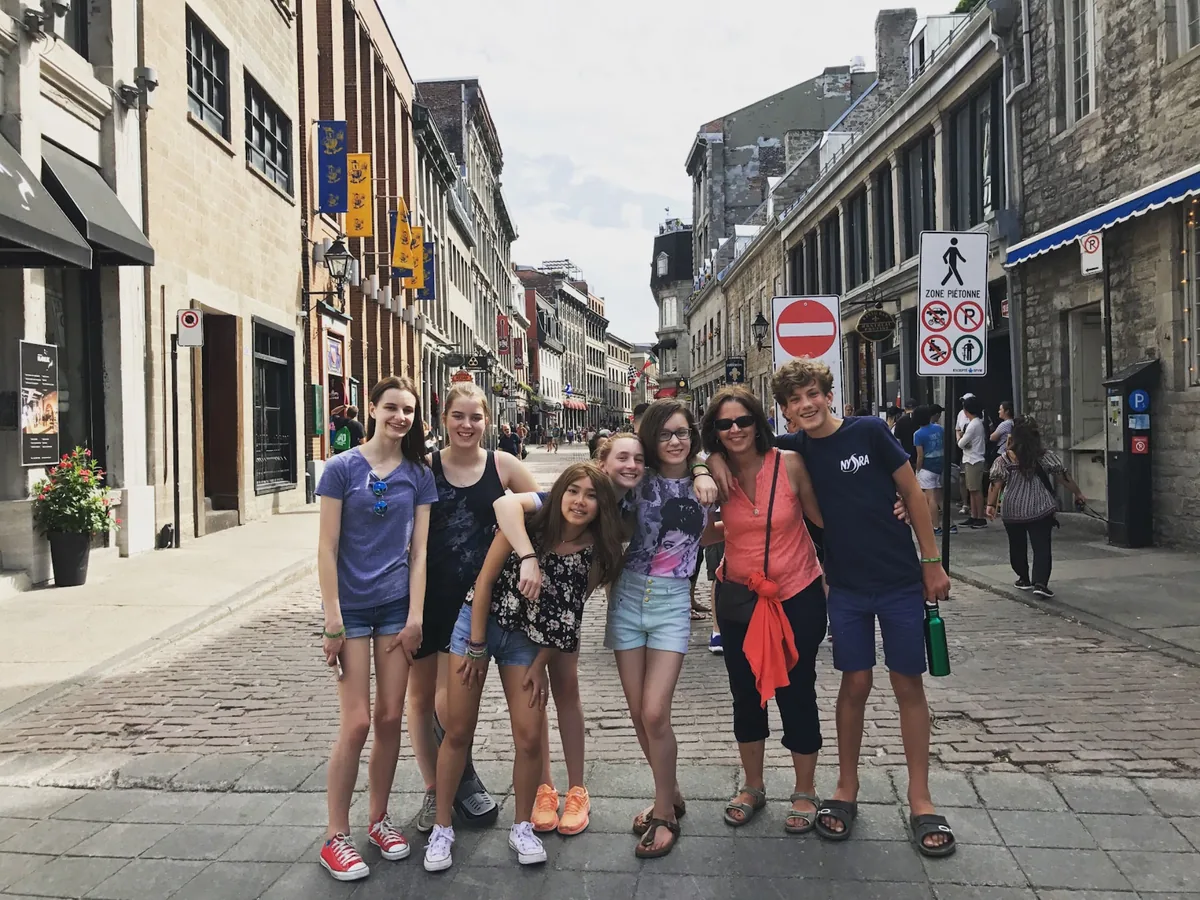 A small group of Landmark students with a chaperone on a cobbled street in Old Montreal