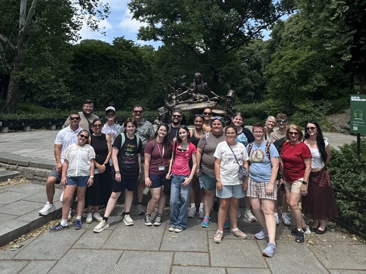 A Landmark group with students and adult chaperones at the Alice in Wonderland statue in Central Park, New York City