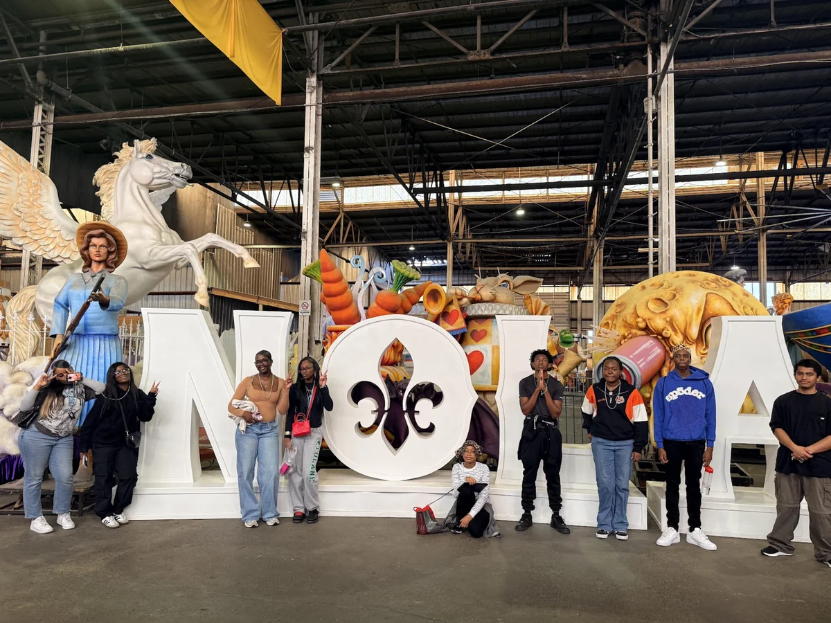 Landmark students beside the NOLA letters among Mardi Gras parade floats in New Orleans