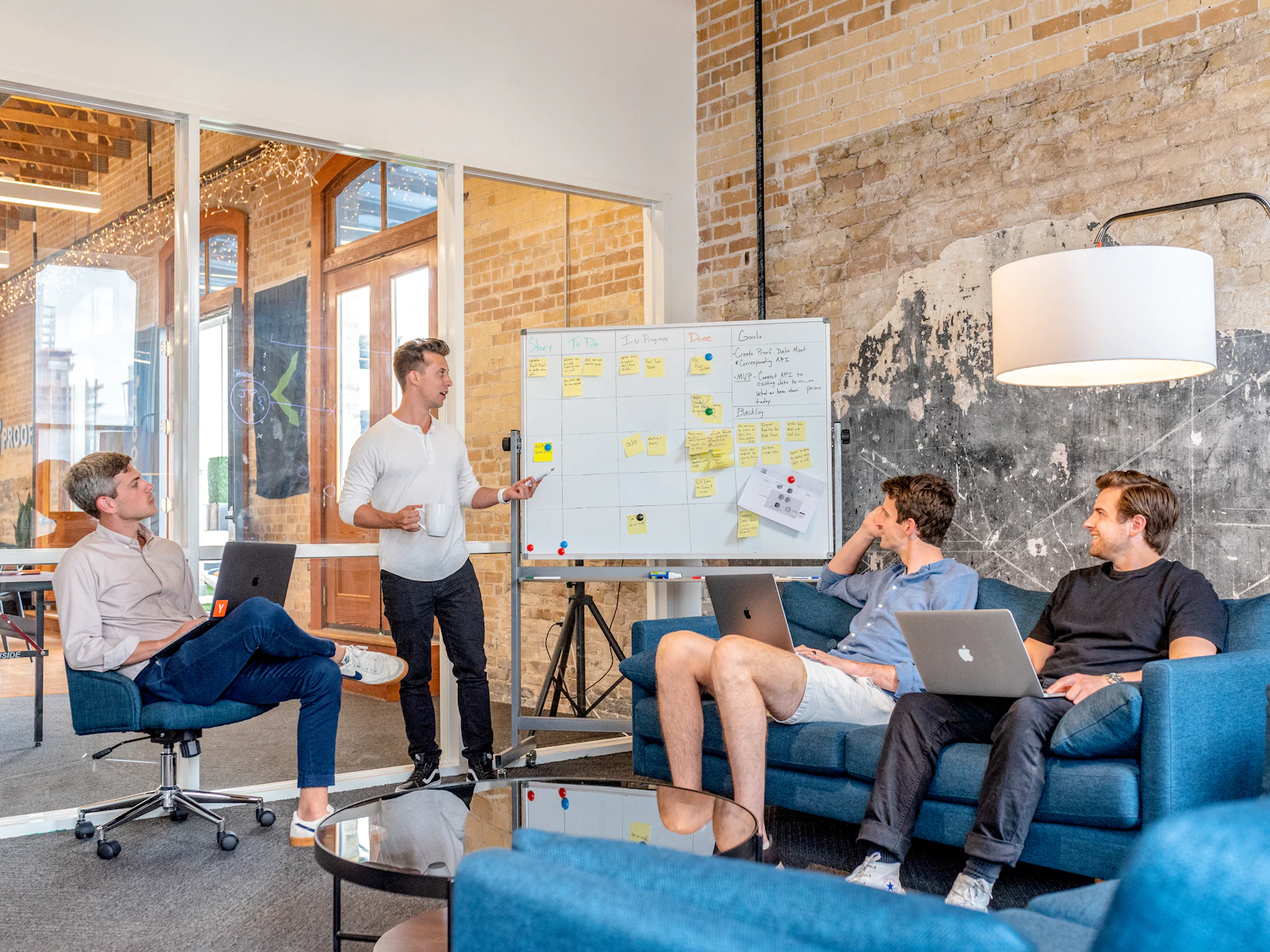 A startup team gathered around a whiteboard in a bright office