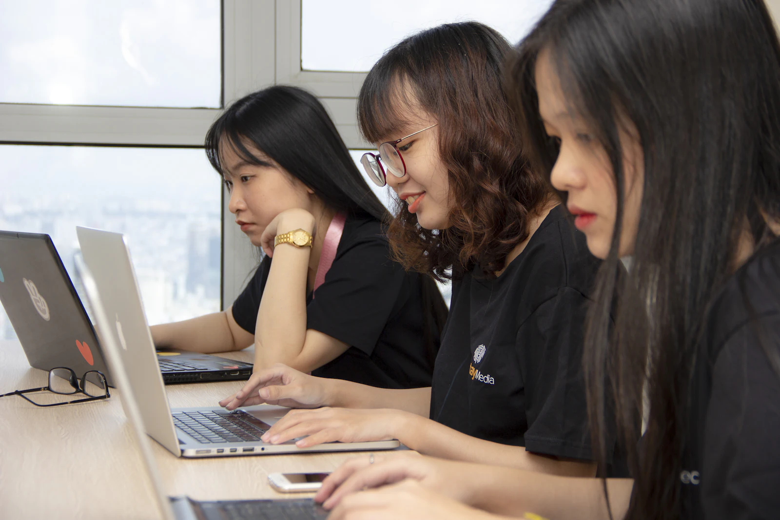 Students working side by side on laptops