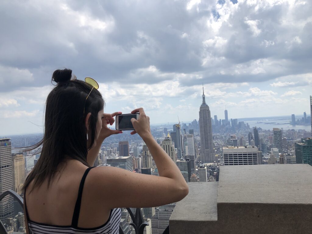 Student taking a picture on the top deck of the Top of the Rock Observatory in NYC.