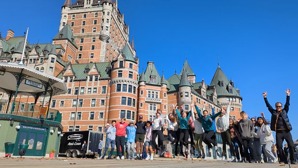group of students jumping in front the chateau frontenac