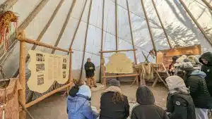 native guide sharing history and culture of the huron tribe in a large teepee