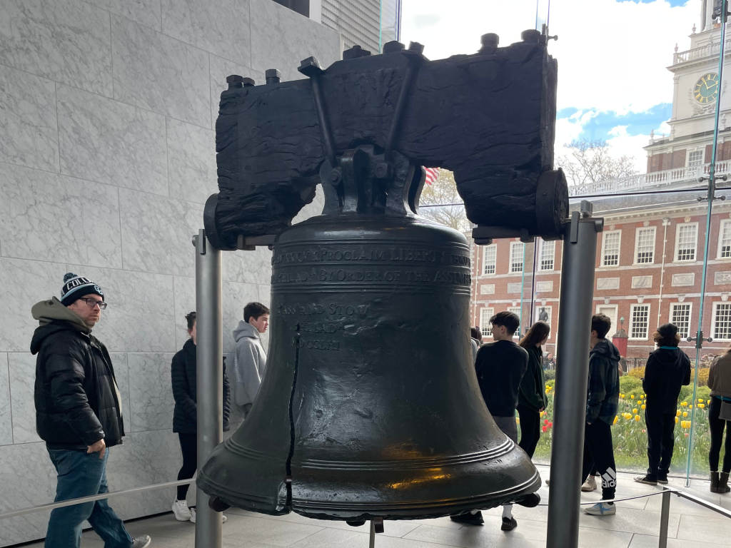 A large bell in front of a building.