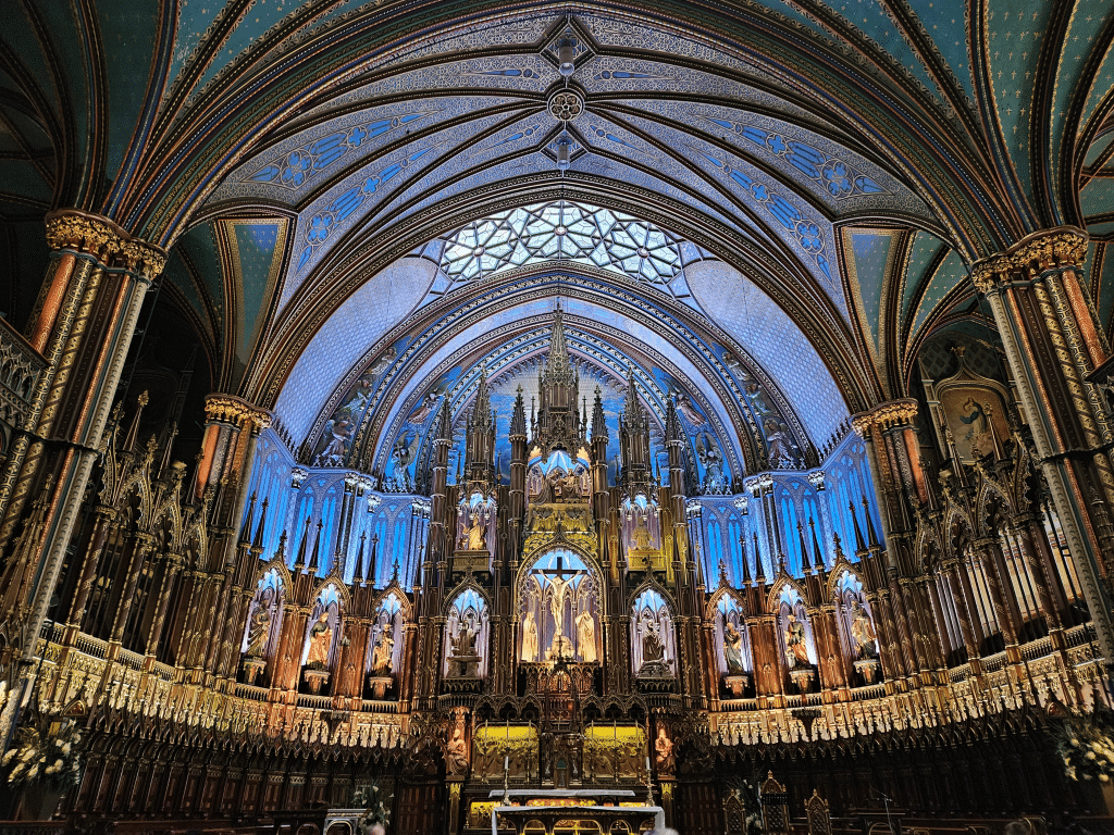 A church with a blue ceiling with Notre-Dame Basilica in the background.