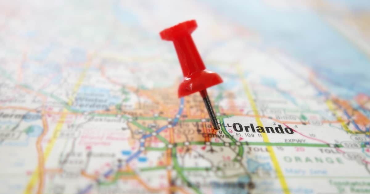 A red push pin sits on a map over Orlando, Florida. The roads are represented by many different colors.