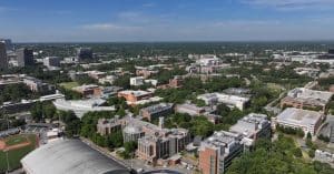 An aerial view of Atlanta during the daytime. There are buildings and a college campus scattered around town.