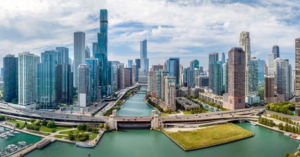 An aerial view of downtown Chicago on a sunny summer day. The river is in the center and leads to the lake.