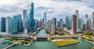 An aerial view of downtown Chicago on a sunny summer day. The river is in the center and leads to the lake.