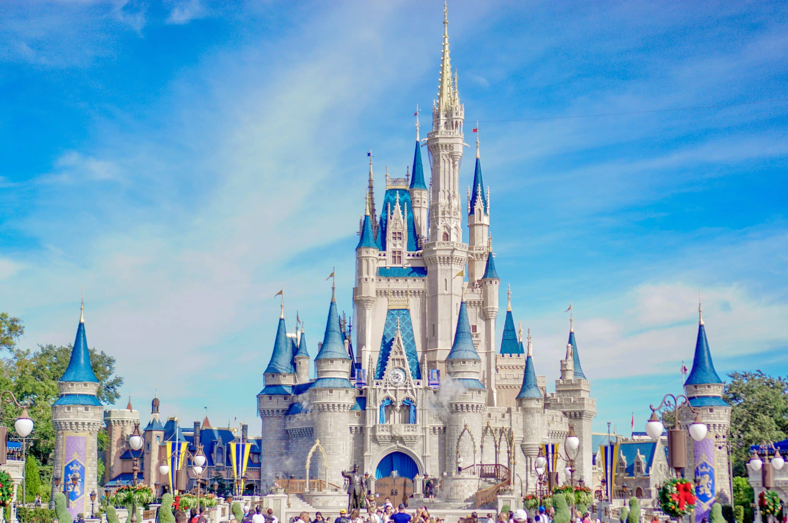 Cinderella Castle at Disney World, featuring blue and gray turrets under a bright sky, remains a must-see landmark—reflecting Student Travel Trends for 2027 as more student groups visit and gather at its iconic entrance.
